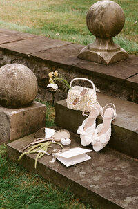 Striking fashion forward bride portrait captured in dramatic architectural lighting by NYC editorial wedding photographer Lauren Alatriste. This luxury destination wedding image showcases the bride's elegant silhouette against the rustic sophistication of Lion Rock Farm's historic stone architecture, embodying the perfect blend of editorial artistry and authentic emotion.
