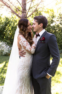 Bride and groom embracing during outdoor wedding portraits