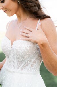 Close up of bride showing her wedding ring and hair blowing in the wind.
