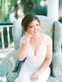 A bride putting on jewelry  on her wedding day in Charleston, South Carolina.