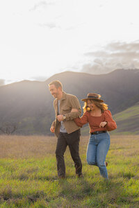 couple running engagement photos by mountains in clayton california