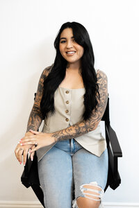 Professional woman with long dark hair adjusting black gloves before a session. Photograph by Yucaipa branding photographer Kaitlyn Dawn Photography.