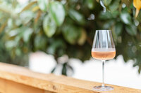 Close up photo of a glass of champagne sitting on a wooden ledge at Sip and Savor for a branding session.