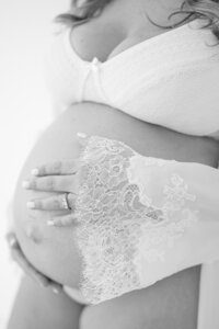 Pregnant woman holding bump close up, fine art maternity photographer South Florida