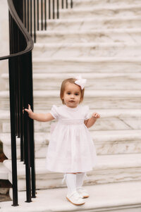 Charleston Baby Milestone Photographer - Toddler peers at the camera during Baby Milestone Portraits in downtown Charleston, SC