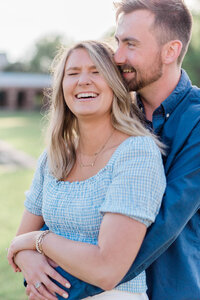 Man holds his partner and she laughs