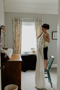 daughter holds up mom's wedding dress