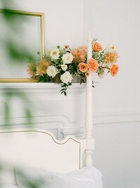 Peach and white floral arrangement on vintage mantel with gold mirror by Flowergirl Cville, Charlottesville area wedding florist | Photo by Lyn Waldrop Photography