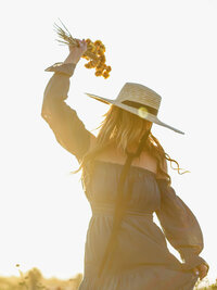 Editorial lifestyle portrait of a creative entrepreneur in natural light holding dried florals