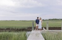 Couple hold hands while standing on dock on Nantucket.