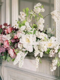 close-up of fireplace arrangement with white peonies, lilac, and soft blush florals in a romantic design