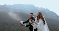 Bride and groom Champagne pop at moraine lake