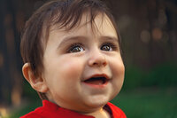 Young boy in red shirt looking upward during outdoor portrait session in New Bern NC