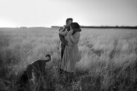 black and white image couple embracing in field