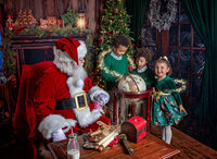 Children gather around Santa's magical globe during a Santa's Magical Christmas photography session in Jacksonville, Florida with Nature's Child Photography, exploring holiday wonder, glowing Christmas magic, and festive North Pole details beside Santa's cozy fireplace.