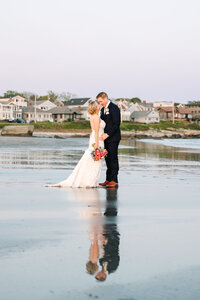 bride and groom embrace on beach at sunset at their Newport Beach House wedding