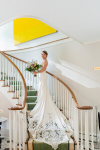 Elegant bride portrait on the stairs of a Los Angeles wedding venue with soft light, refined styling, and a fine art look.