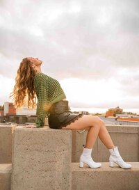 Senior girl flipping her hair on a parking garage rooftop in downtown Mobile, Alabama.