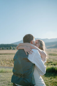 bride in front of crested butte kissing husband