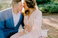 Engaged couple kissing in the rays of sun