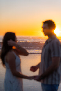 engagement couple running on beach together in santa cruz