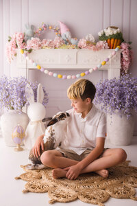 Little boy pets a live bunny during Easter Mini Session at Holy City Babies Portrait Studio in Charleston, SC.