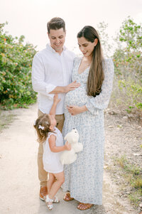 Toddler reaching for pregnant belly in Key Biscayne, maternity photos with kids