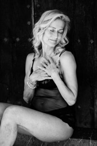 Boudoir experience studio woman seated in front of wooden doors