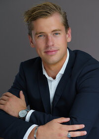 Young man with blonde hair posing in a blue jacket and a nice watch for a modeling portfolio