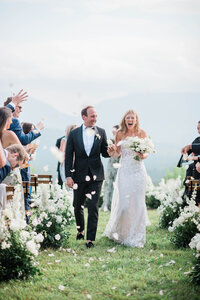 Bride and groom happily walk down the aisle