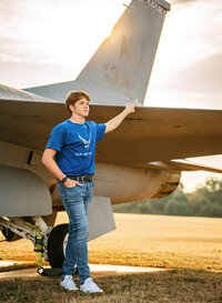 Senior portrait at Battleship Memorial Park in Mobile, Alabama— leaning against the wing of a fighter jet.