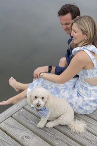 Couple hold hands while sitting on dock on Nantucket.