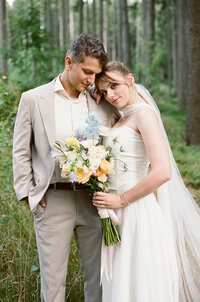 Newlyweds are posing after their ceremony in the woods captured on analog