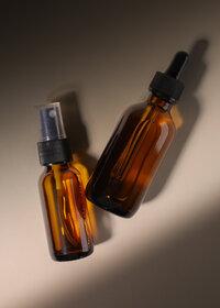 Studio product still of amber glass bottles in directional light