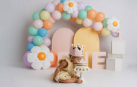 Cake Smash Photographer in Charleston, SC - Baby smiles at the camera during Cake Smash Photoshoot at Holy City Babies in Charleston, SC.