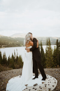 couple hugging at their Colorado elopement in front of the mountains. They eloped in Breckenridge colorado on the top of a mountain where they said their vows and celebrated with family and friends. Plan your Breckenridge elopement with me and we will find the best and most secluded mountain elopement locations in Colorado!