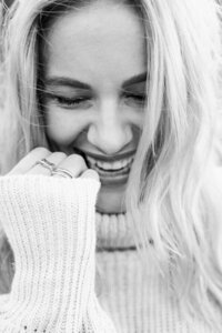 Branding foto van blonde vrouw met lange mouwen en hand bij haar gezicht