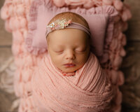 Newborn baby wrapped in light pink on a textured blush blanket. Photographed by Inland Empire newborn photographer Kaitlyn Dawn Photography.