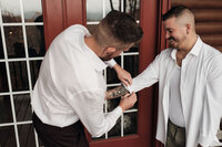 Couple helps each other get ready on their wedding day