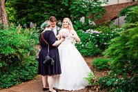 Mahlia assisting bride with dress and bouquet in the outdoor courtyard at Gaylord Opryland