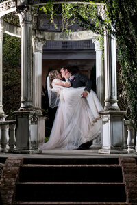 a person dipping their partner and kissing them in the middle of a gazebo