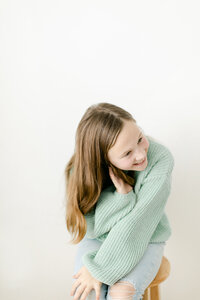 girl in green sweater laughing