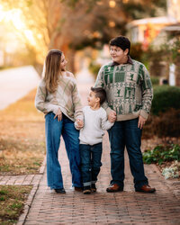 Two siblings smiling at each other during an outdoor family session in New Bern