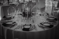 Table de réception dressée avec chandeliers en verre, verrerie en cristal et assiettes à motifs, centre de table végétal, ambiance élégante au Centre des sciences de Montréal