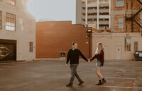 Couple holding hands and walking in a parking garage in the city