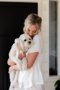 Bride holding dog during getting ready portraits