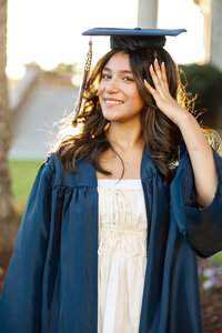 Close-up portrait of a smiling high school senior girl in a white blouse, senior photos by Kaitlyn Dawn Photography.