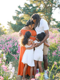 A family embracing in the the field of blooming sweet peas