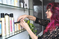 Portland hairstylist adjusting the hair products on her shelf