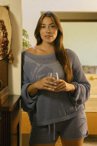 Woman holding a glass of water in the kitchen in soft daylight